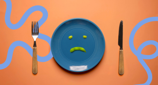 Arte mostra um prato azul com um molhinho em formato de carinha triste, sobre um fundo cor de laranja.
